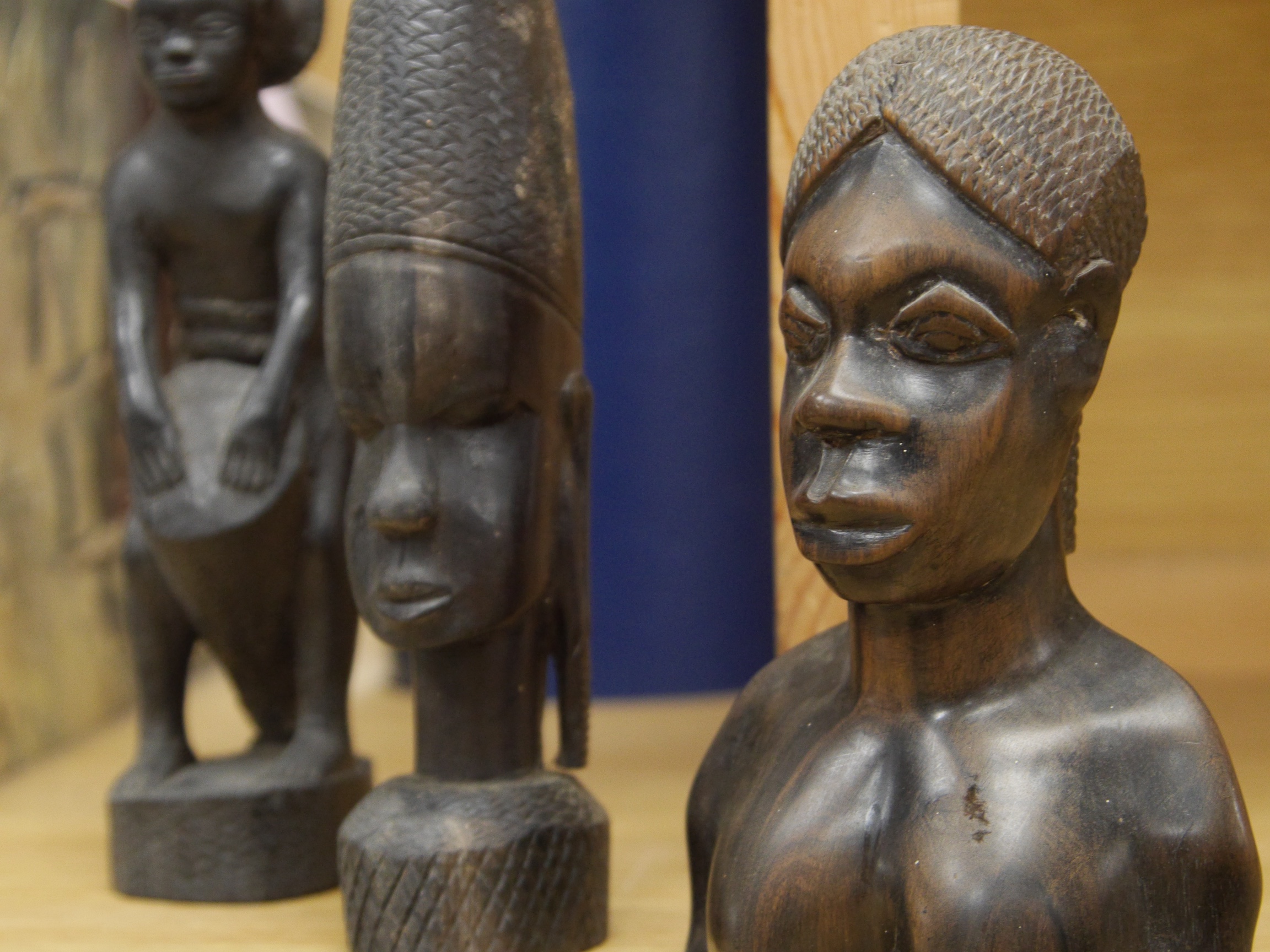 Four African wood carvings to include a figure and a pair and another bust, tallest 27cm. Condition - fair to good